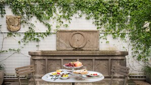 Une table ronde sur laquelle sont disposés divers aliments, ainsi que deux chaises en bois.