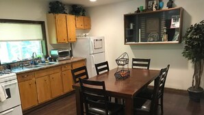 A kitchen with wooden cabinets, a microwave, a refrigerator, and a dining table with chairs. - Serene location in middle of wine country  (Westfield)