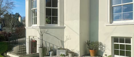Un edificio de dos pisos con ventanas grandes y fachada blanca.