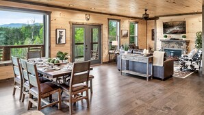 Un intérieur spacieux en bois, comprenant un coin repas, une cuisine et de grandes fenêtres donnant sur l’extérieur.