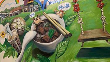 A mural with a traditional Chinese building, a bowl of soup, and a monkey character.