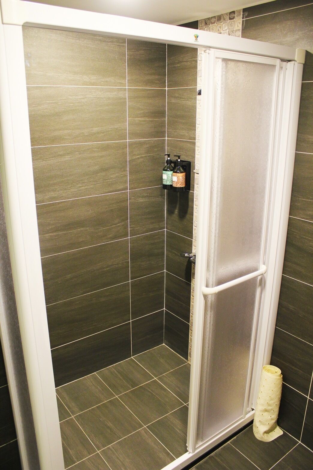 Een douche, een regendouche, een haardroger, pantoffels