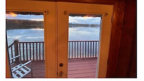 A wooden cabin with a view of a calm lake and a sunset. - Right On The Water (Wautoma)