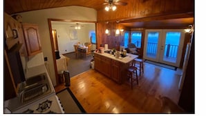 A spacious kitchen with wooden cabinets, a central island, and a dining area with a table and chairs. - Right On The Water (Wautoma)