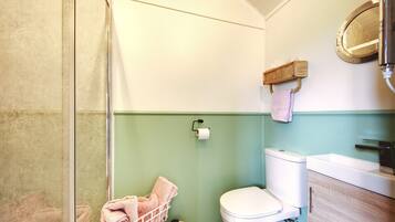 Une salle de bain comprenant des toilettes, un lavabo et un espace douche.