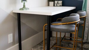 A desk with a computer monitor, a sign saying "DON'T WORRY BE HAPPY," and two chairs with a dark blue wall and a window with curtains in the background. - Your Quiet Place with private entrance (Brandon)