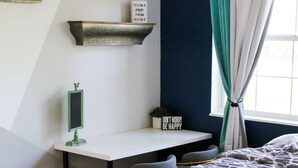 A bedroom with a bed, a desk, and a window with curtains. - Your Quiet Place with private entrance (Brandon)