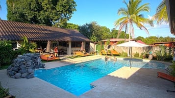 Una piscina al aire libre, camas de piscina gratis, sombrillas