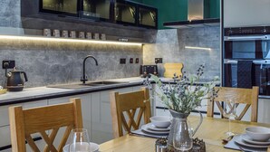 Een moderne keuken met een ingebouwde oven, een spoelbak en een eethoek gedekt voor een maaltijd.
