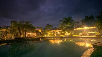 Una piscina al aire libre, sombrillas, tumbonas