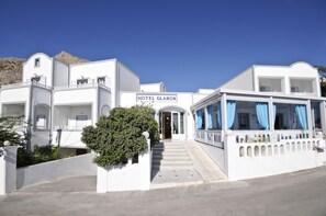 A white building with a sign reading "HOTEL GLAROS." - Hotel Glaros (Santorini)