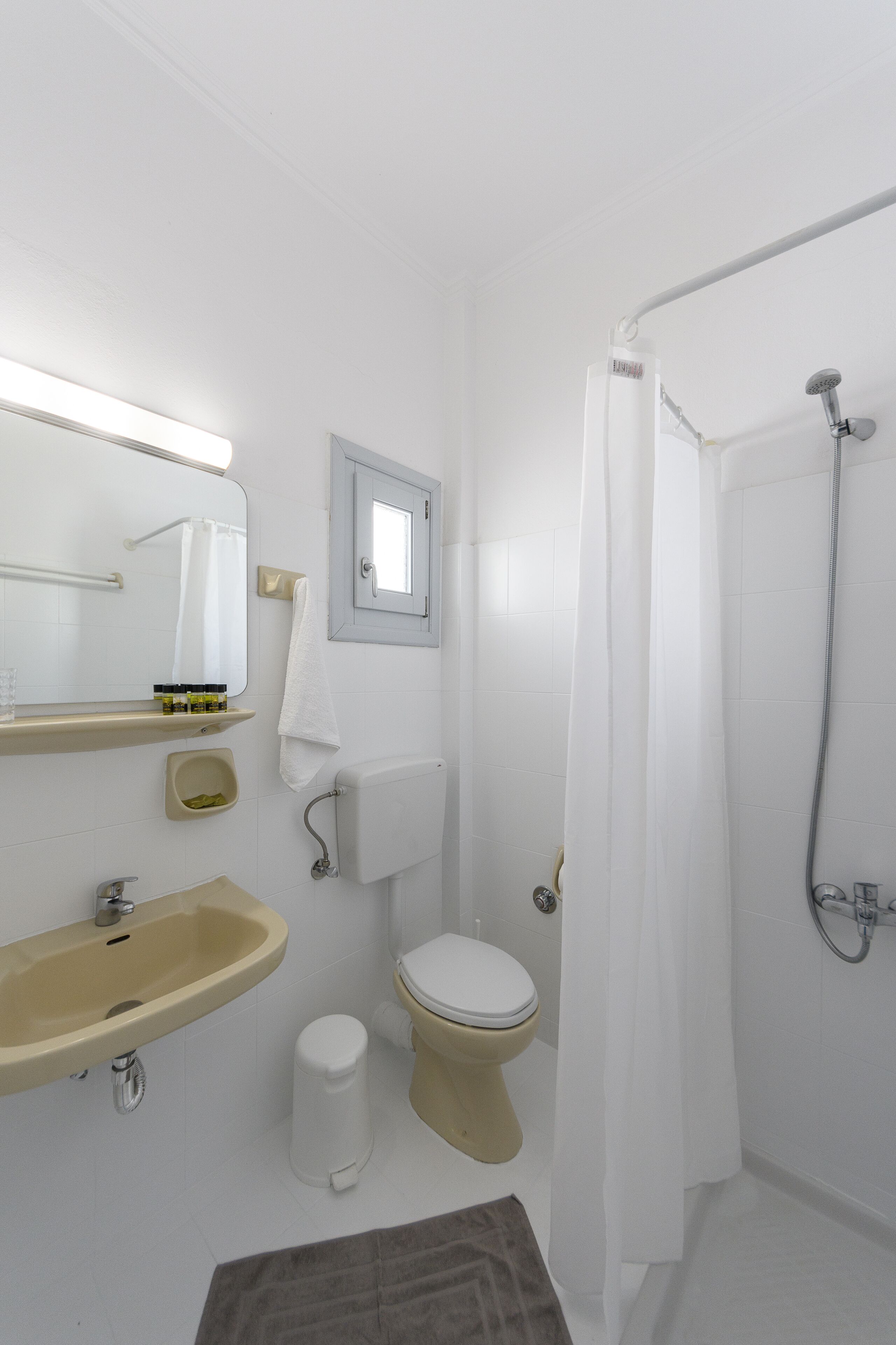 Un baño con lavamanos, inodoro y ducha.