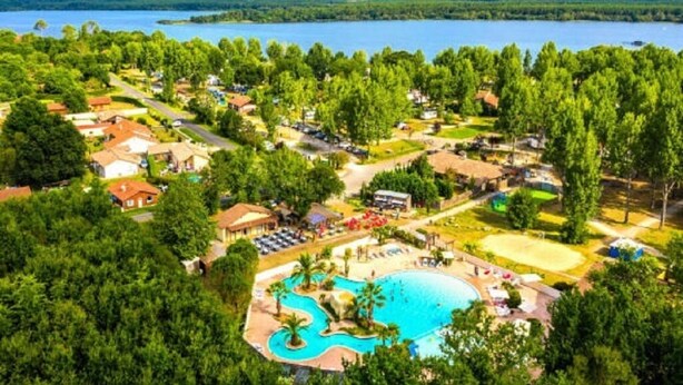 An aerial view of a resort with a large swimming pool, multiple buildings, and a lake in the background. - La Roque d'Anthéron - Mobil-home - 6 pers - 3 bdrms - Swimming pool (La Roque-d'Anthéron)