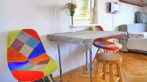 A room with a table, chairs, and a stool.