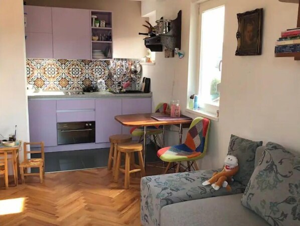 A compact living space with a kitchen, dining area, and a sofa.