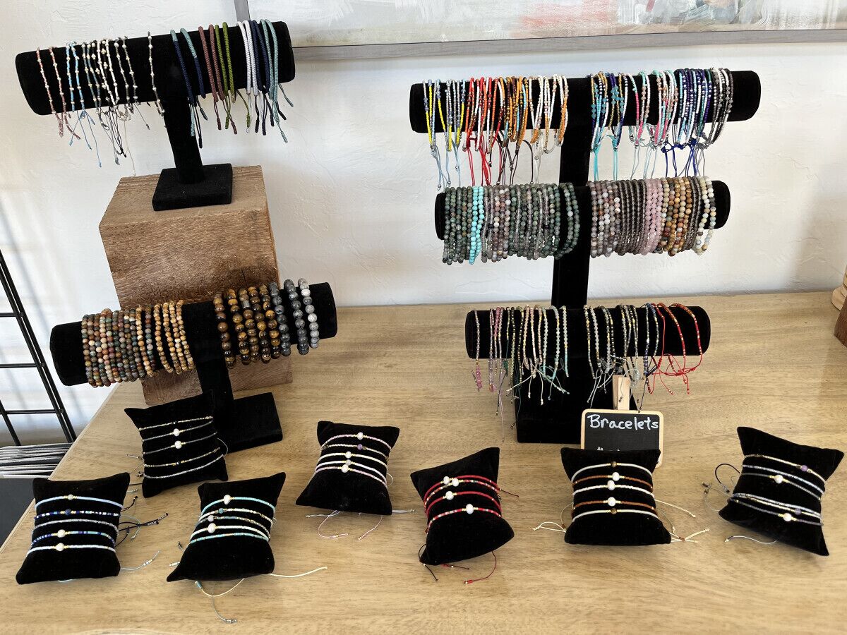 Un présentoir à bijoux avec des bracelets et des coussins décorés de perles.