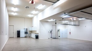 A spacious, well-lit indoor area with a kitchenette, a door, and a fire extinguisher. - Lake View Oasis Pool/Spa+Boat Garage+Ice Machine (Lake Havasu City)