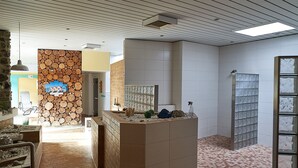 Aula, jossa on kiviseinä, laatoitetut seinät, vastaanottotiski ja laatoitettu lattia.