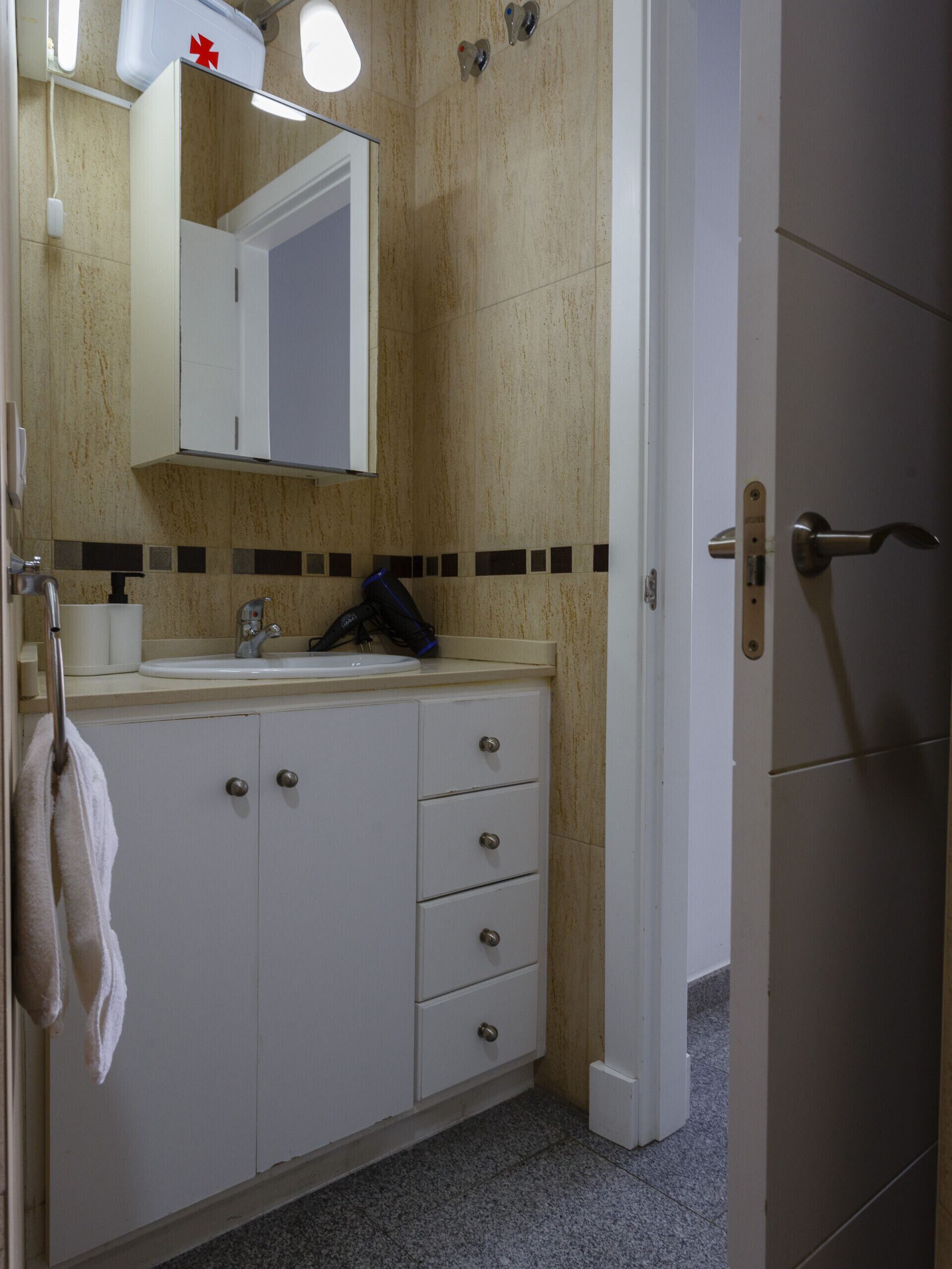 A bathroom with a sink, mirror, and cabinets.