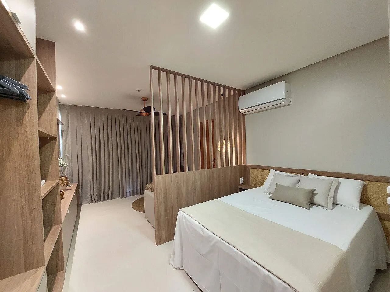 Une chambre d’hôtel comprenant un lit, une armoire, une cloison et un appareil de climatisation.