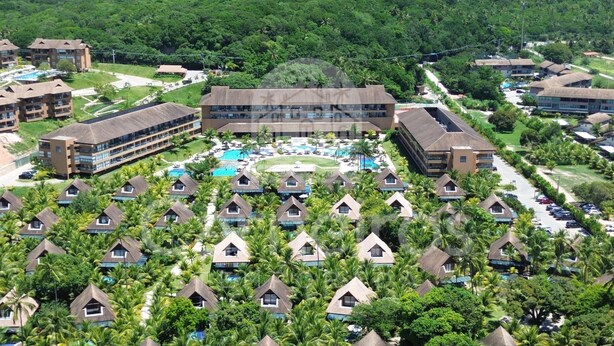 A resort with multiple bungalow-style accommodations, a central pool area, and lush greenery surrounding the buildings.