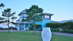Un restaurant de fruits de mer avec une enseigne indiquant « Seafood Eatery » et « The Oyster Farm Seafood Eatery », situé devant un bâtiment bleu doté d’un porche.