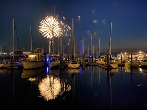 Boats docked in a serene marina at night, surrounded by calm waters.