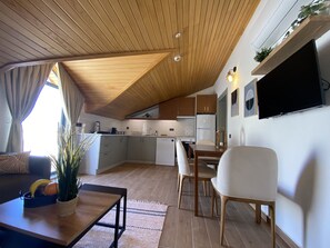 Deluxe appartement | Woonruimte | Een 32-inch smart-tv met satellietzenders en een televisie