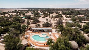 A resort with a large swimming pool, multiple guest rooms, and a view of the surrounding landscape. - Hotel Tantakuy Eco Experience (Pozo Almonte)