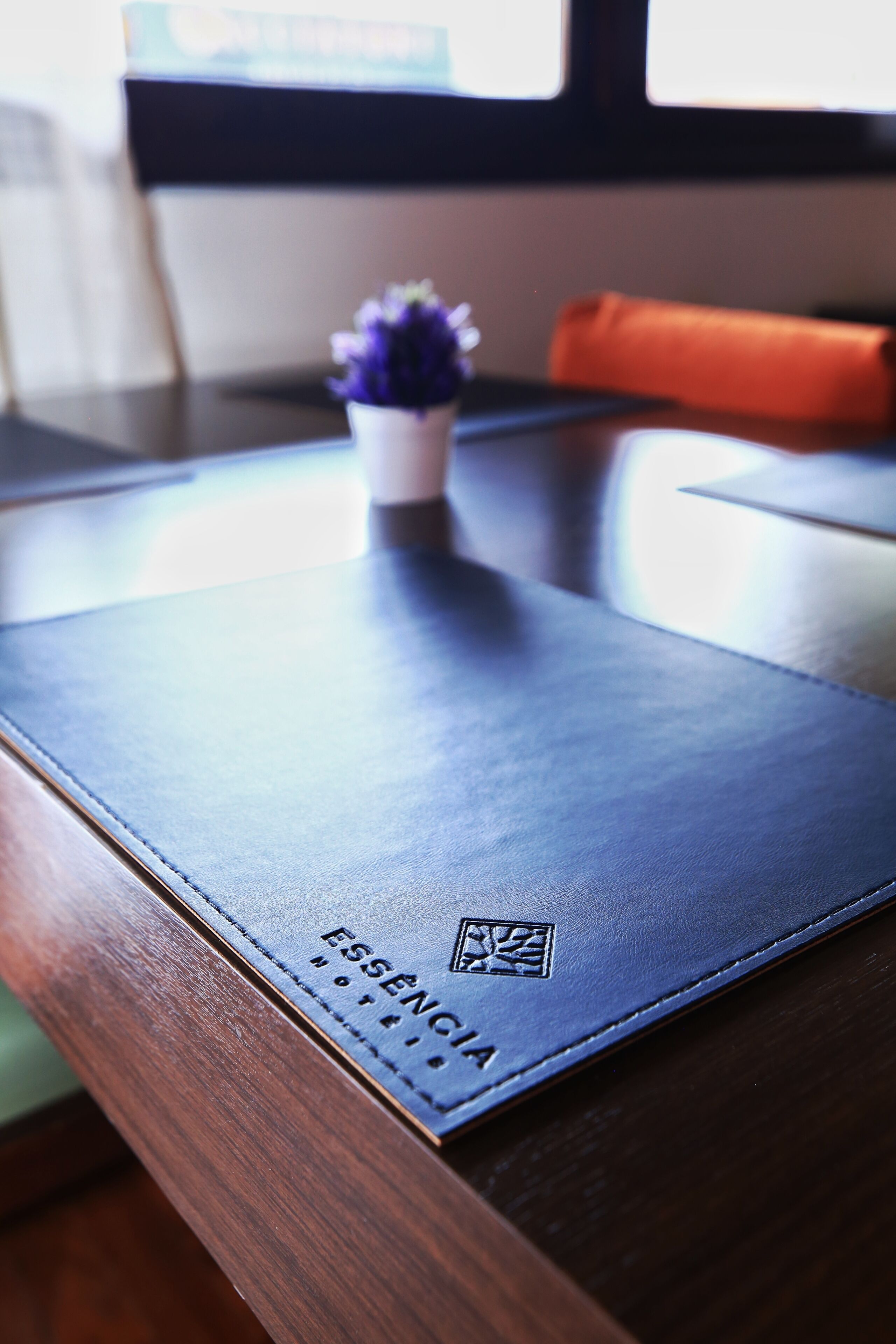 Una mesa de madera con una libreta de cuero azul etiquetada 