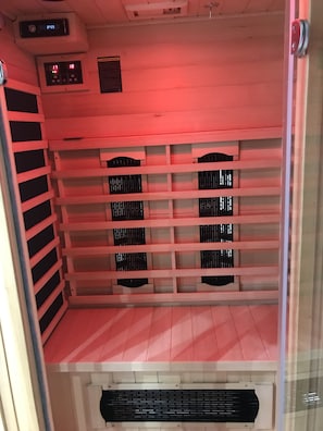 A room with a wooden slatted ceiling, a black ventilation grille at the bottom, and a digital clock displaying 01:25.