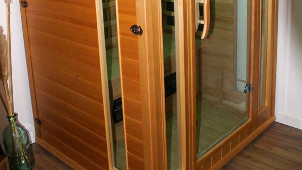 Een houten kast met glazen deuren en een handgreep.