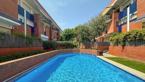 A rectangular swimming pool with clear blue water, surrounded by brick walls and greenery. - Ocean Spirit House by Hello Homes Sitges (Sitges)
