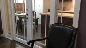 A black leather chair with ornate gold detailing in a room with a wooden floor and a patterned rug. - Secluded Cottage on Cattle Farm and Dog Friendly All Sizes (Vienna)
