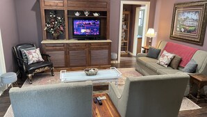 A living room with a television, a sofa, a chair, and a coffee table. - Secluded Cottage on Cattle Farm and Dog Friendly All Sizes (Vienna)