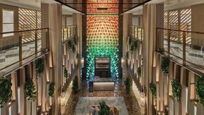 Eine moderne Hotelhalle mit einer zentralen Rezeption, hohen Decken und einem strukturierten Wanddesign.