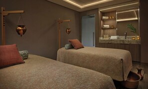 A modern hotel room with two beds, a small bathroom, and a vanity with toiletries. - The Grand Mayan 1x1 Suite (Cabo San Lucas)
