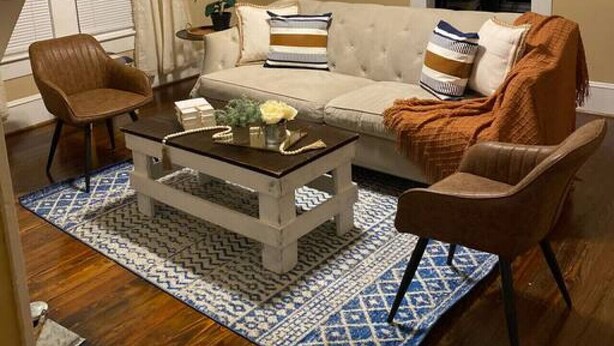 Un salon comprenant un canapé, deux fauteuils, une table basse et un ventilateur de plafond.