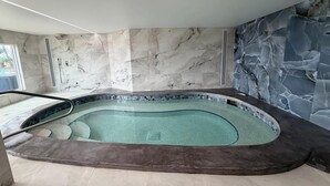 A spa area with a hot tub, marble walls, and a tiled floor. - Enjoy “BEACH LIFE”.  Breathtaking Beach Front Condo, Great Balcony & Amenities! (Panama City Beach)