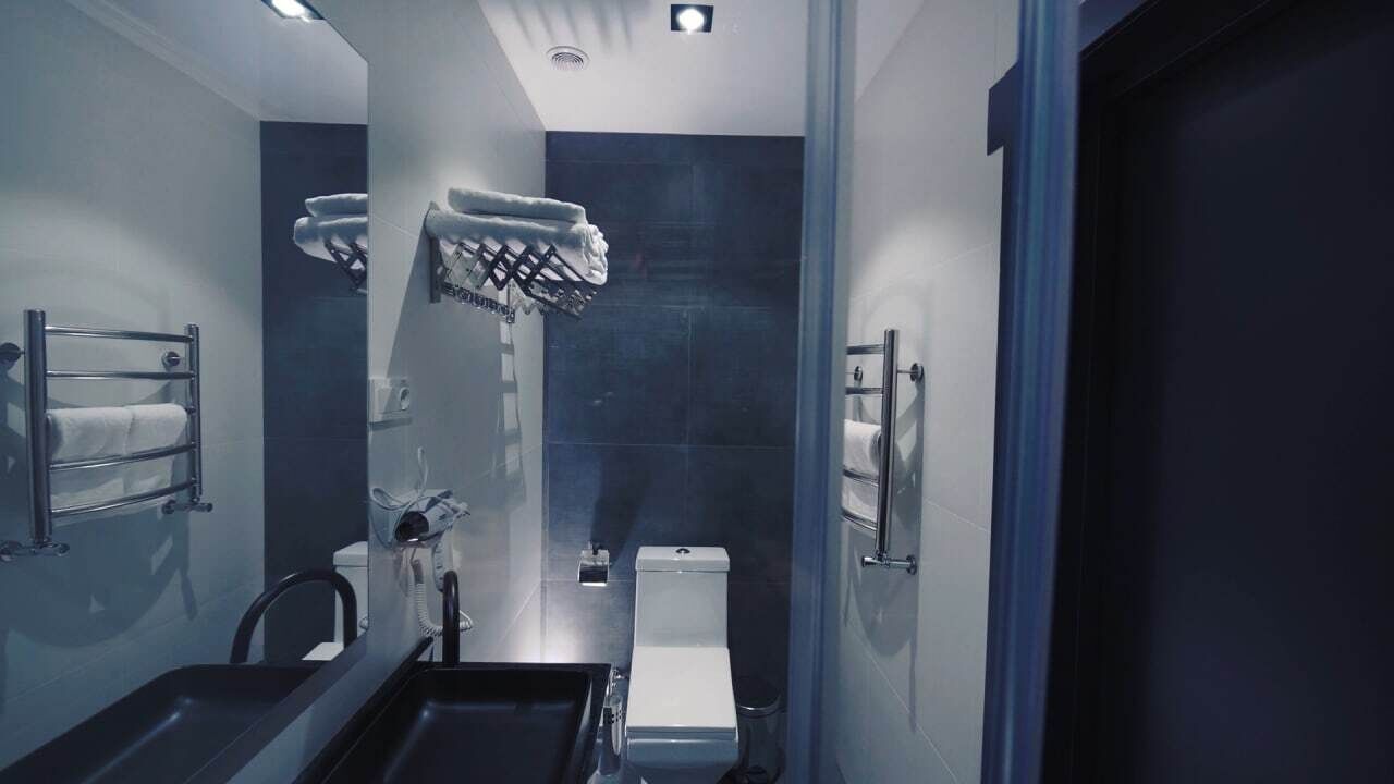 A modern bathroom with a built-in shower, a toilet, and a sink.