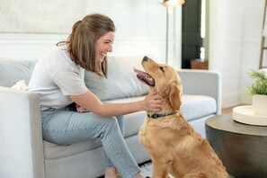A person sitting on a sofa with a dog. - Walk to Riverside Park, Splashpad, Trails + Dining, near Downtown Lynchburg! (Lynchburg)