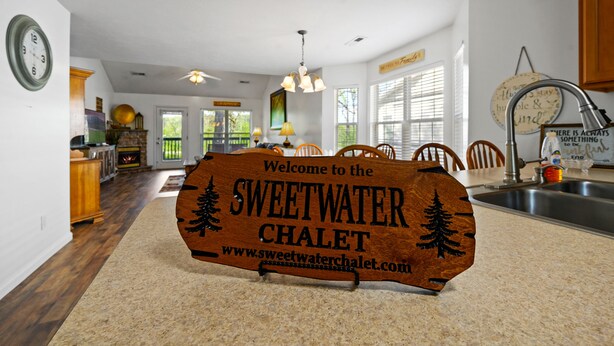 A wooden welcome sign for Sweetwater Chalet with a website URL. - Bright and Breezy Riverfront Chalet (Pigeon Forge)