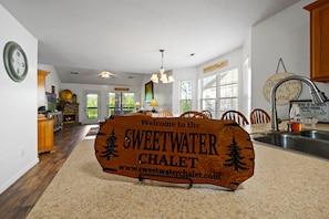 A wooden welcome sign for Sweetwater Chalet with a website URL.
