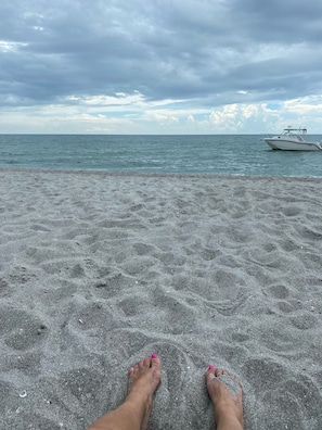 Relax on the unadorned beach, perfect for sunbathing or water activities.
