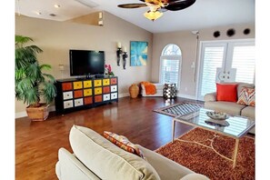 Relax in this stylish living room with a large flat-screen TV, comfortable sofa, and glass coffee table.