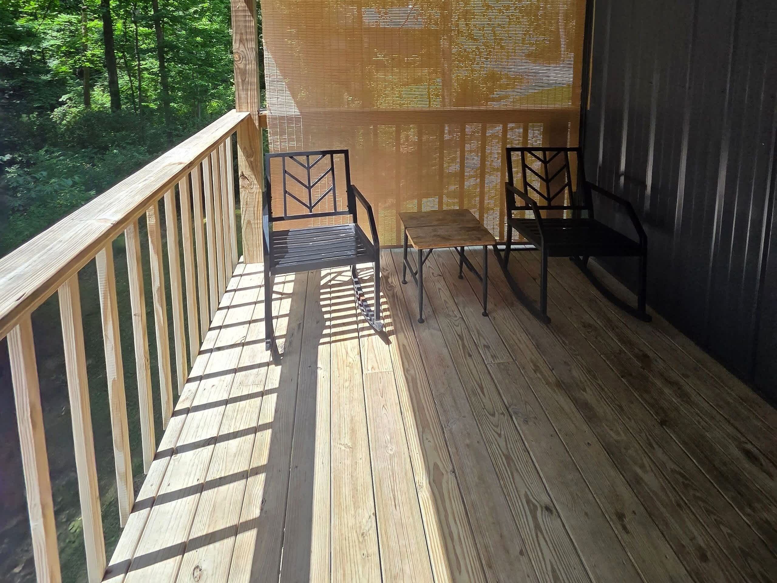 Une terrasse en bois avec une rambarde, un banc et une table.