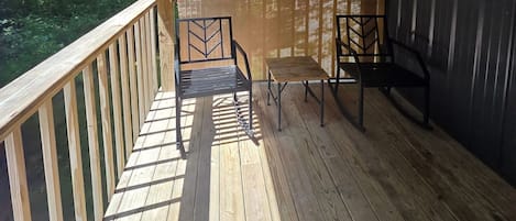 Une terrasse en bois avec une rambarde, un banc et une table.