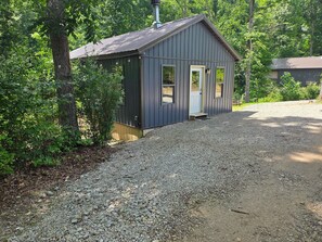Un petit bâtiment d’un seul étage, avec un toit en métal et une allée gravillonnée.