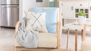 Ein gemütliches Wohnzimmer mit einer Couch, einem Couchtisch und einem Schrank.