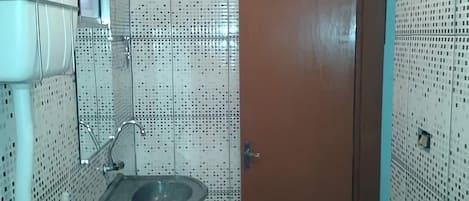 Une salle de bain avec un lavabo, un miroir et une porte.
